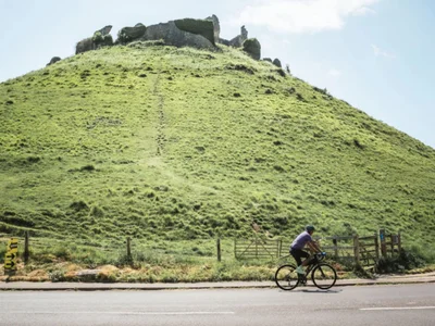 lone cyclist in front of Corfe Castle